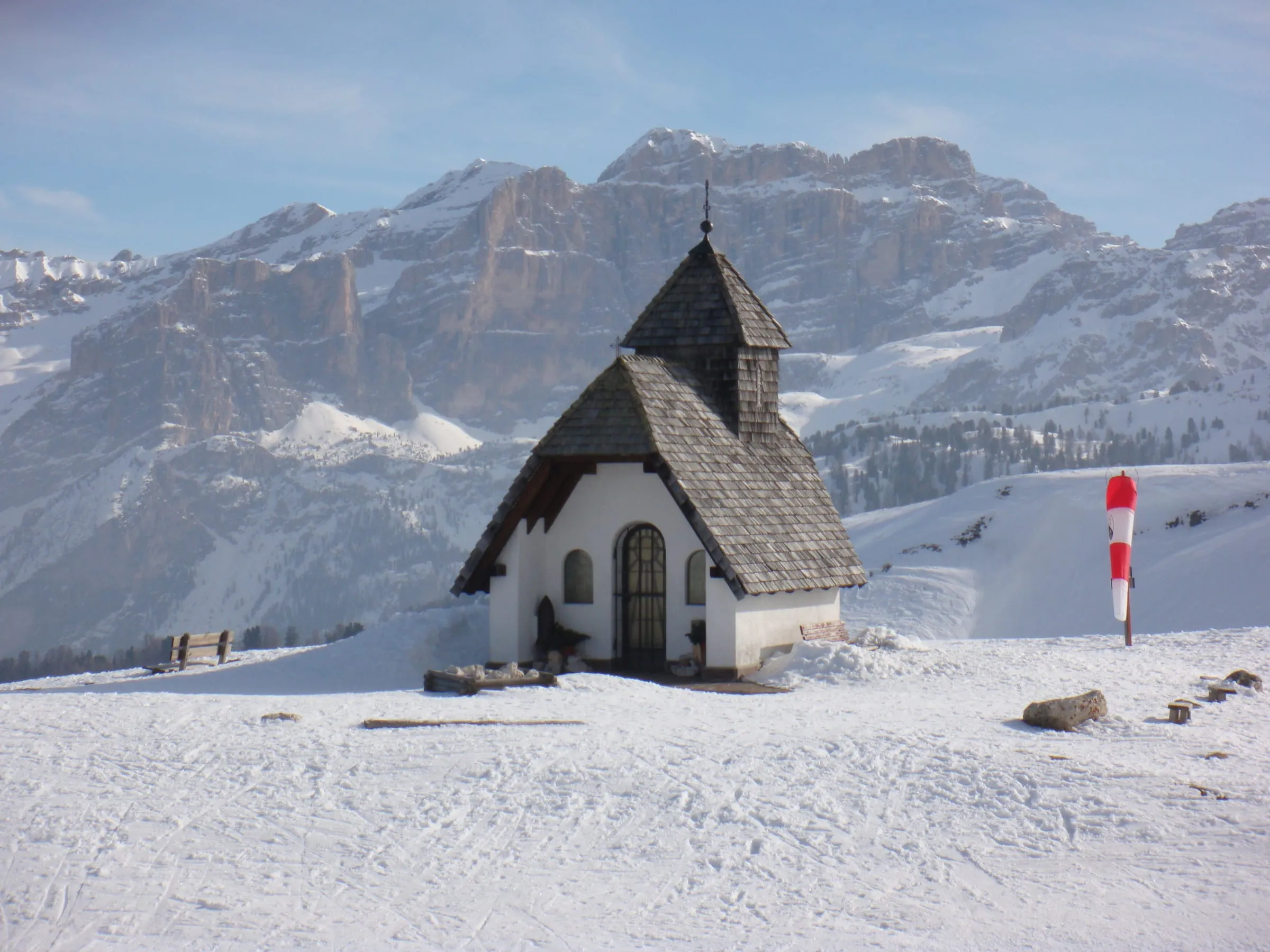The small chapel on the snowy Pralongia plateau in Alta Badia, with Dolomite peaks behind