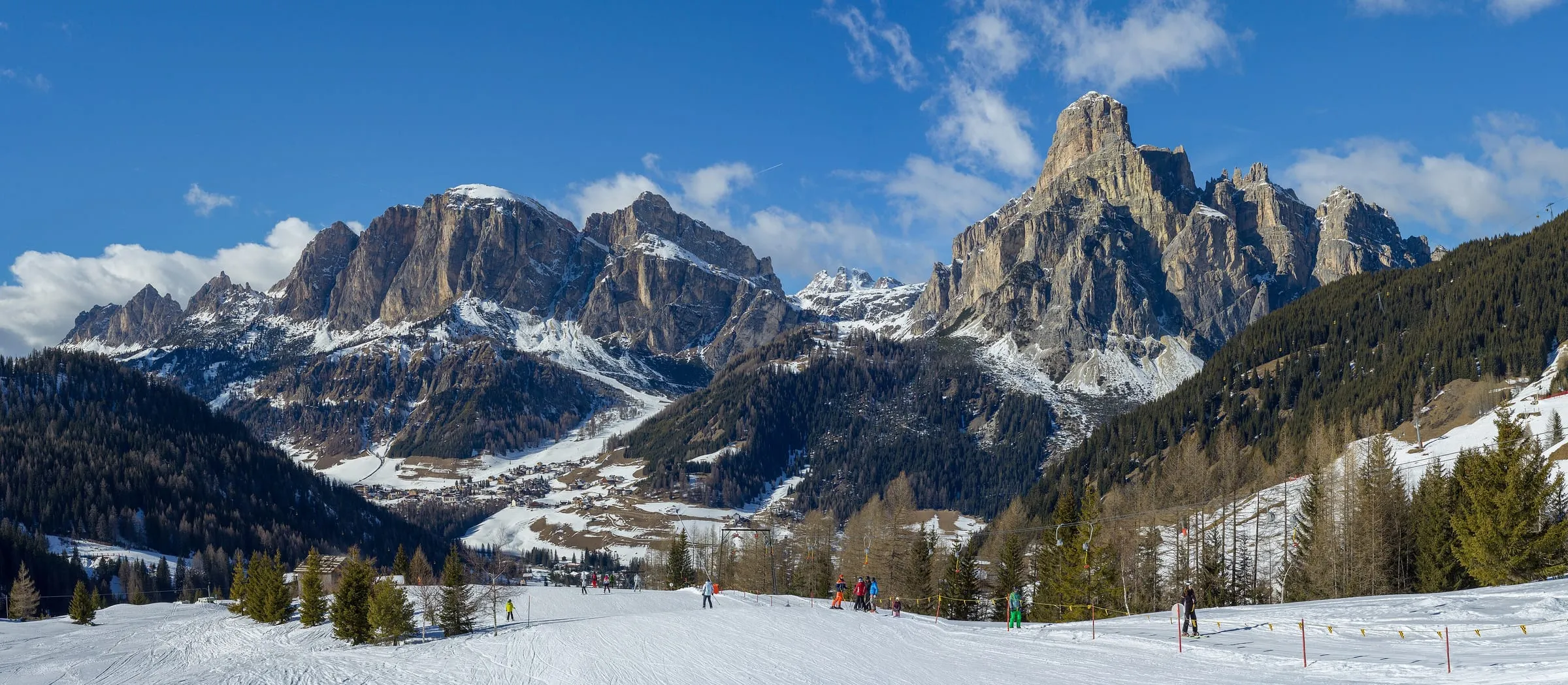Corvara in Alta Badia below the Sassongher, with ski slopes in the foreground
