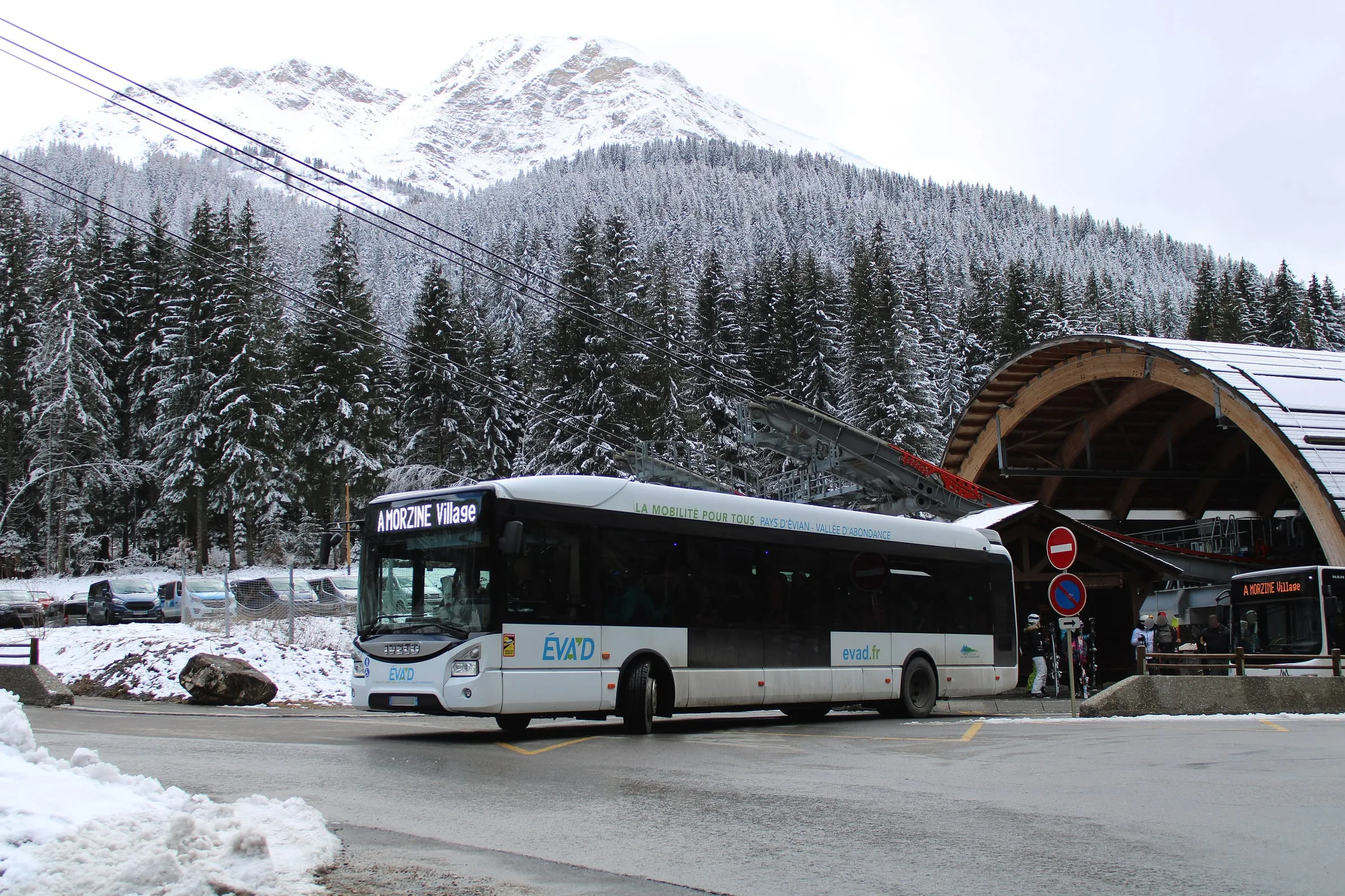 A bus waiting at the foot of the Prodains cable car below Avoriaz, with snowy forest behind