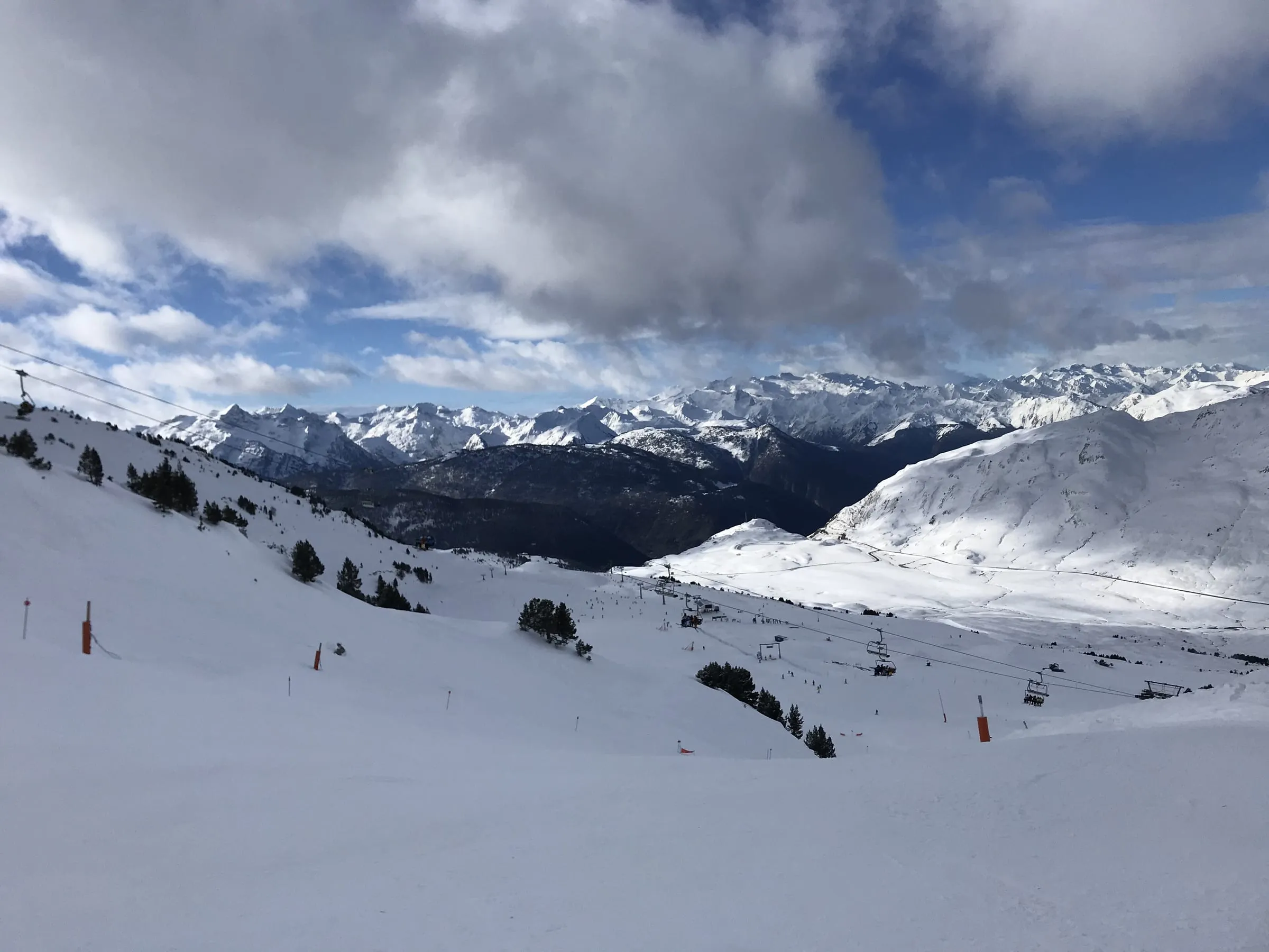 Snowy slopes and chairlifts at Baqueira-Beret with the Pyrenees stretching to the horizon