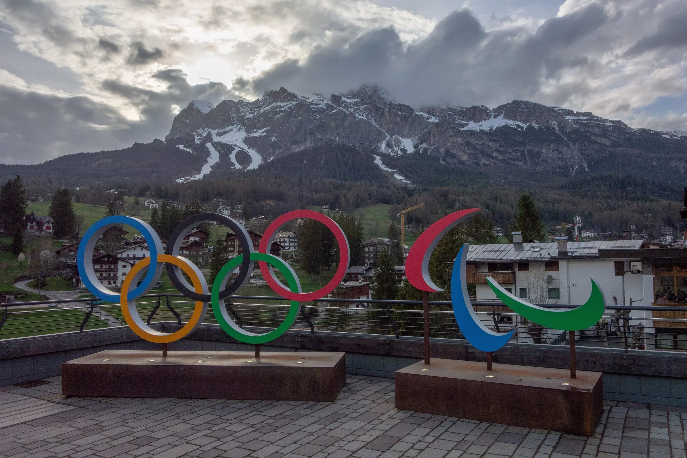 The Olympic and Paralympic rings installation in Cortina d'Ampezzo, with snowy Dolomite peaks behind