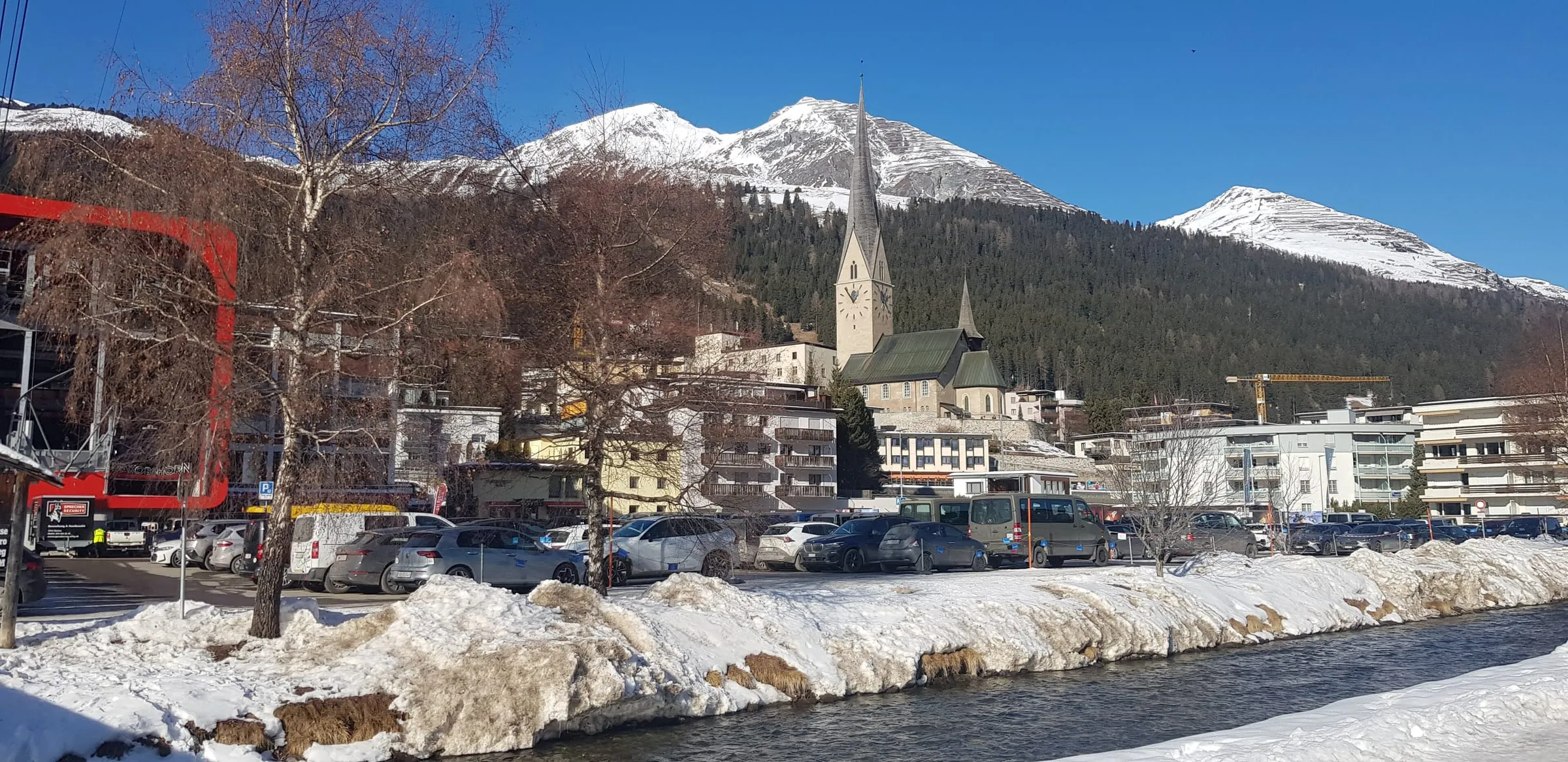 St. Johann church and the centre of Davos Platz in winter, with snowy peaks behind