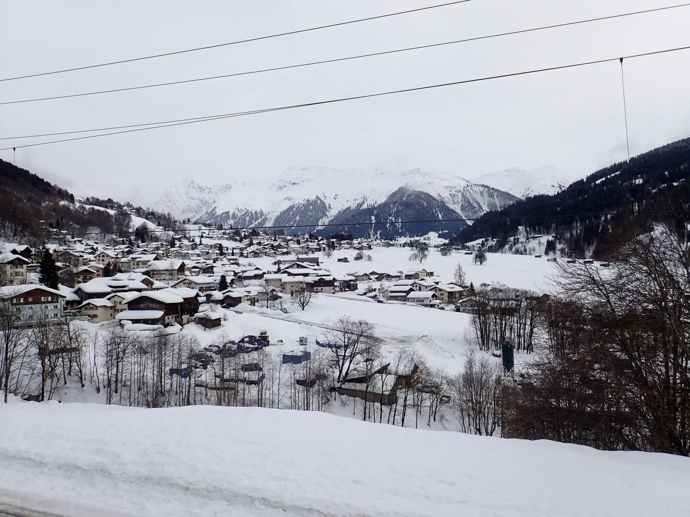 Klosters Dorf in winter, chalets in the snow below the mountains