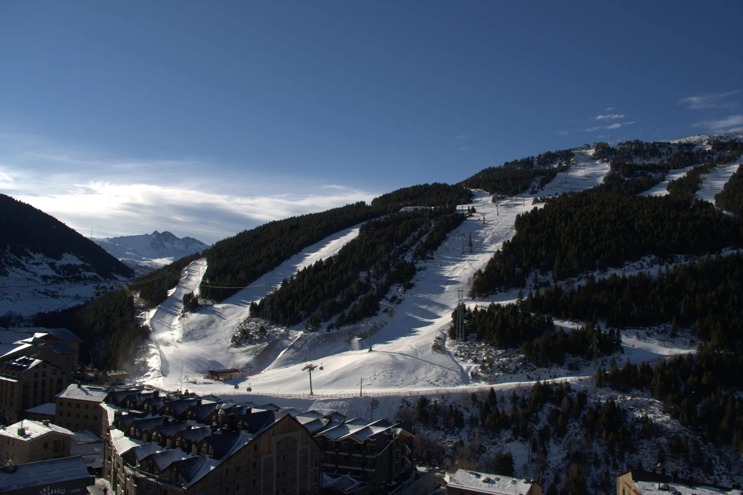 The village of Soldeu with its ski slopes running down through the forest above it