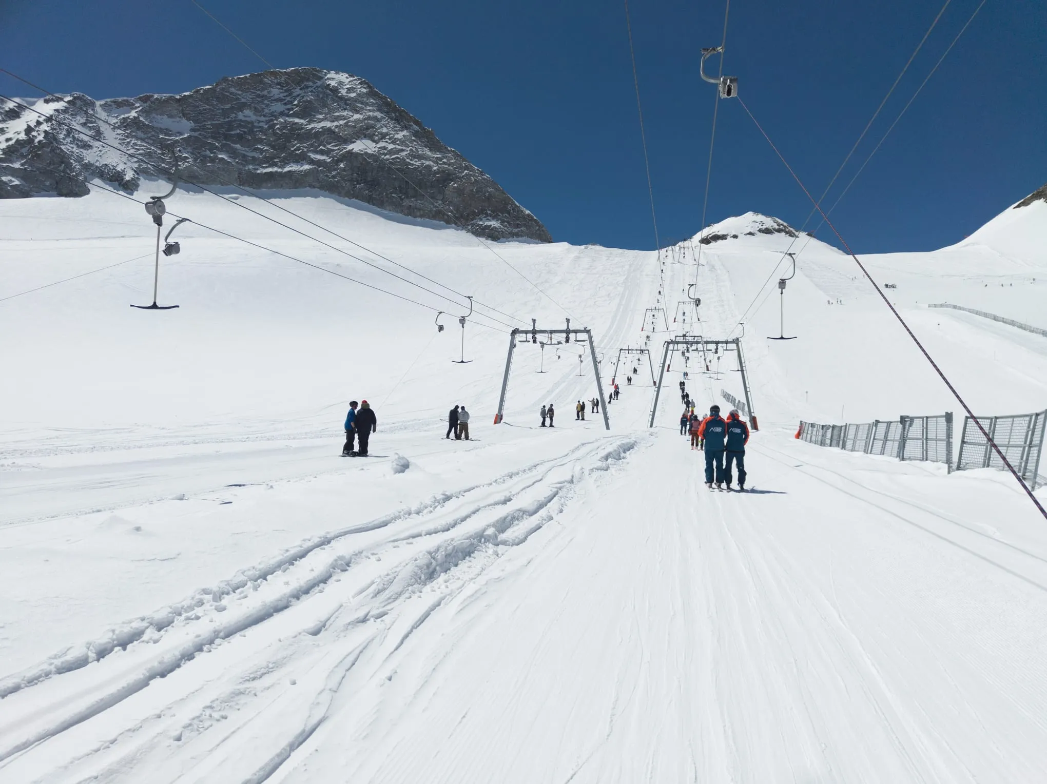 T-bar lifts and skiers on the snowy Hintertux Glacier in spring