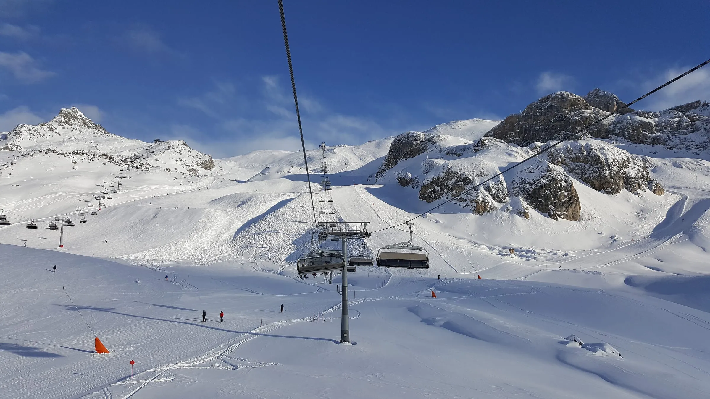 A chairlift and groomed pistes below rocky peaks in the Silvretta Arena, Ischgl