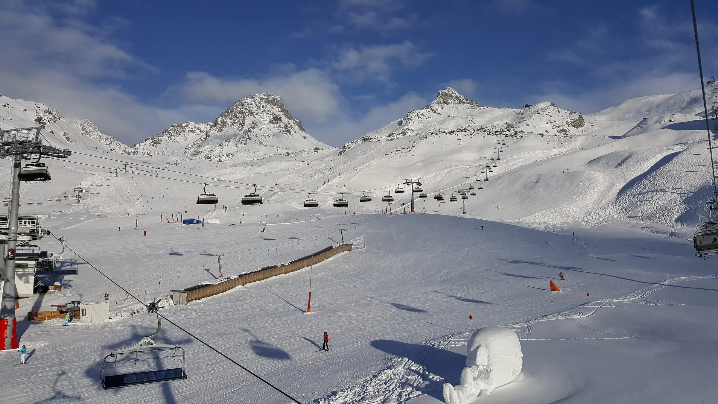 Wide groomed pistes and chairlifts in the Ischgl ski area under a blue sky