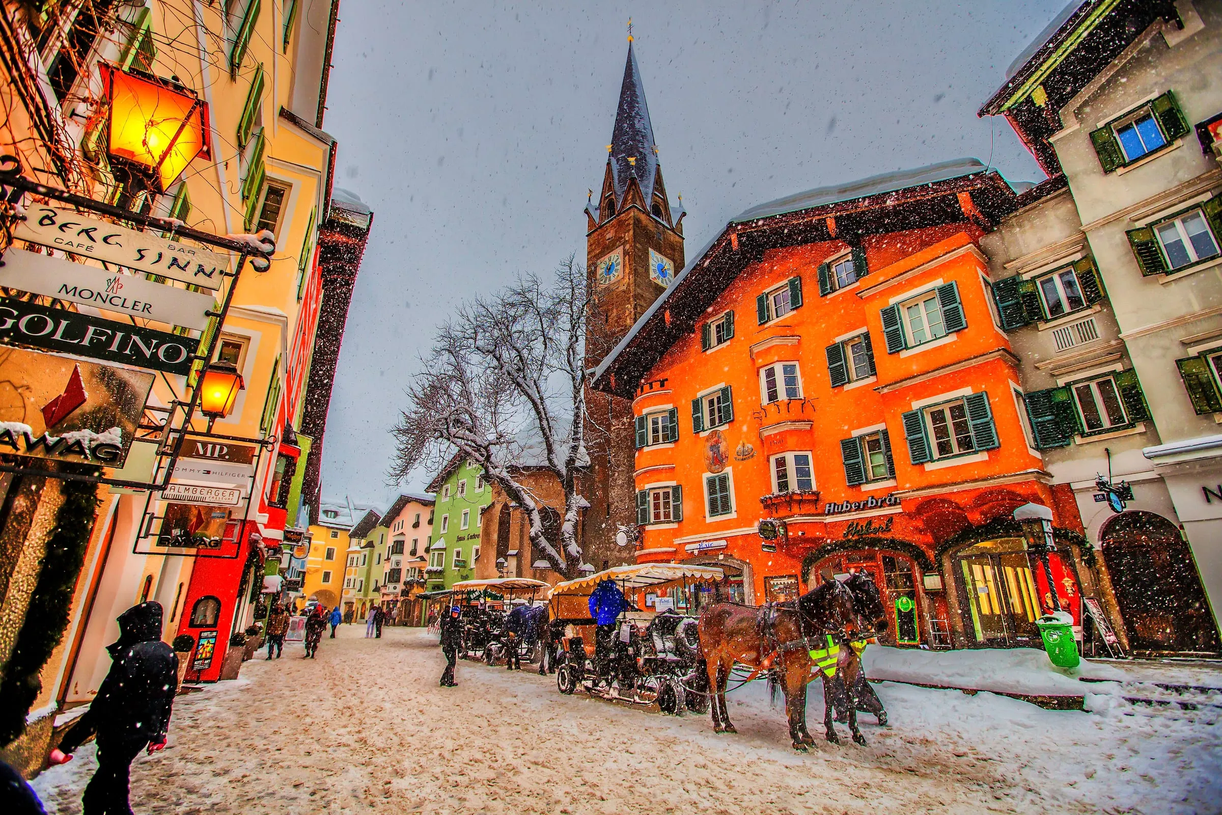 Kitzbühel’s old town in winter, with horse-drawn sleighs in the snowy street
