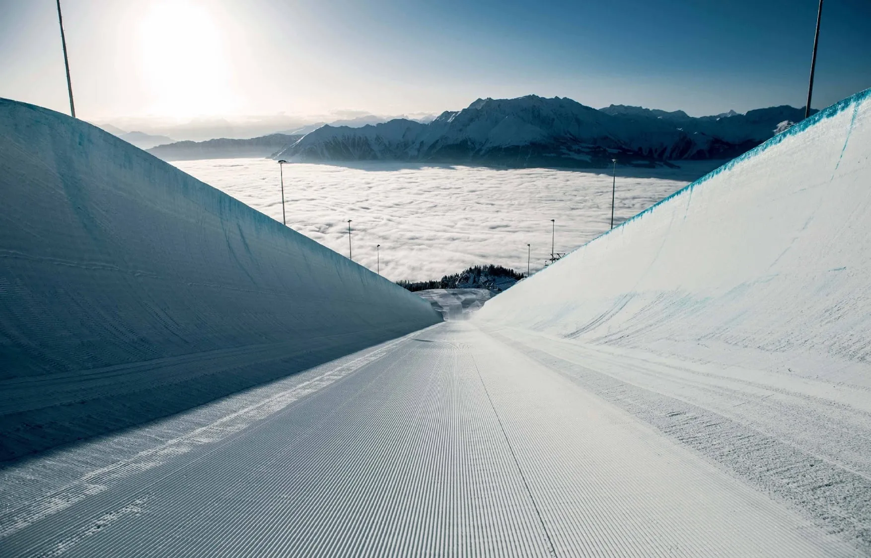 The superpipe in the LAAX snowpark, a long freshly shaped halfpipe above a sea of cloud