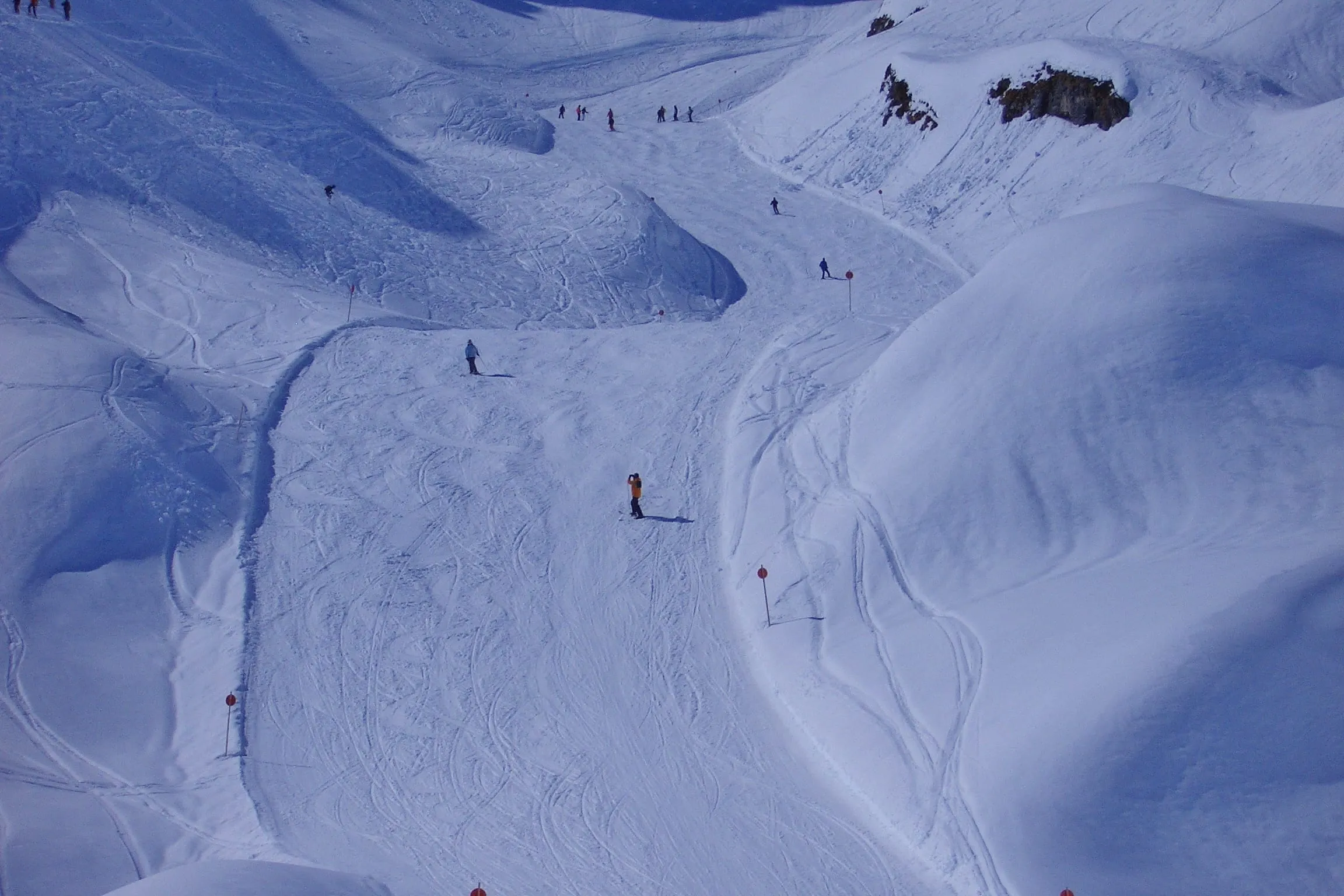 Skiers on wide pistes on the descent from the Muggengrat towards Zürs