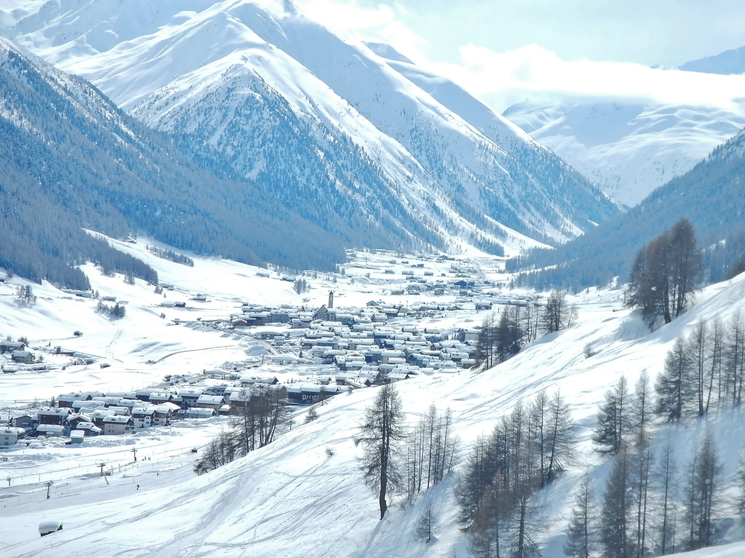 Livigno village spread along its valley floor in winter, seen from the slopes