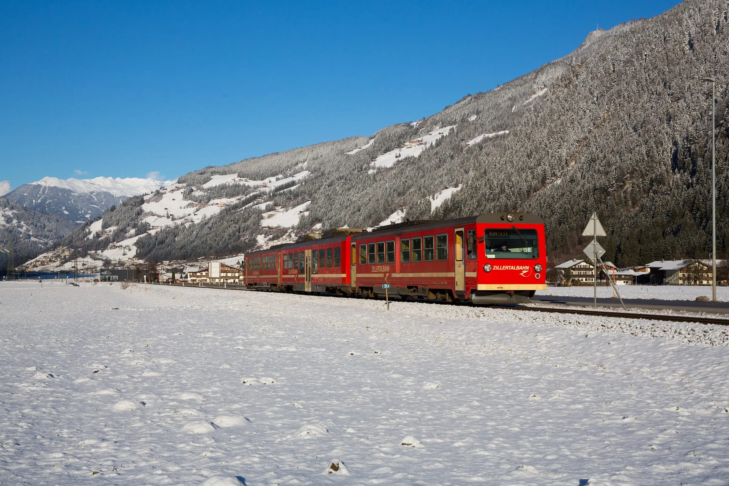 A red Zillertalbahn train in the snow near Mayrhofen station