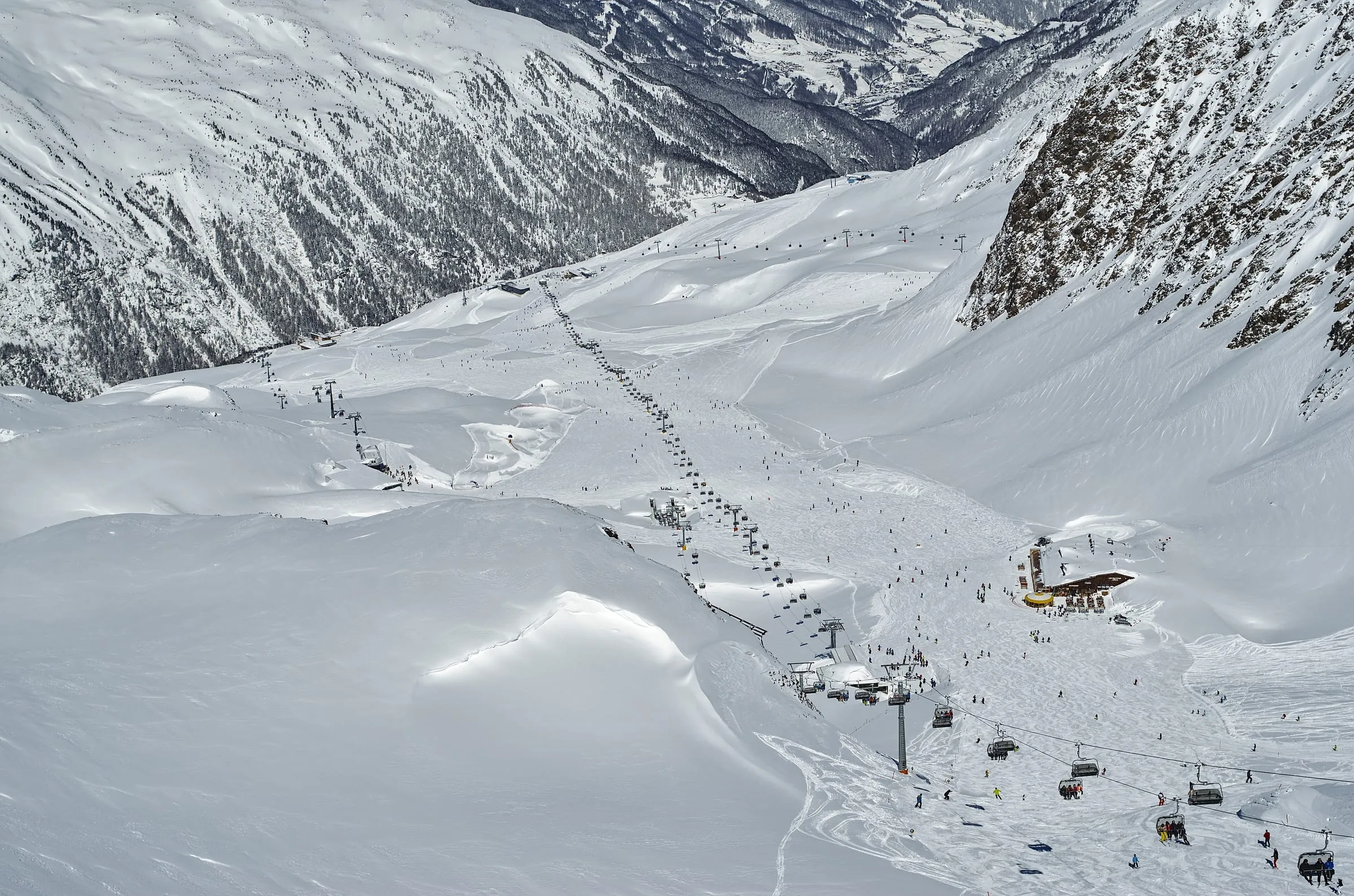 A chairlift climbing over snowy pistes in the Obergurgl-Hochgurgl ski area, with the Gurgl valley below