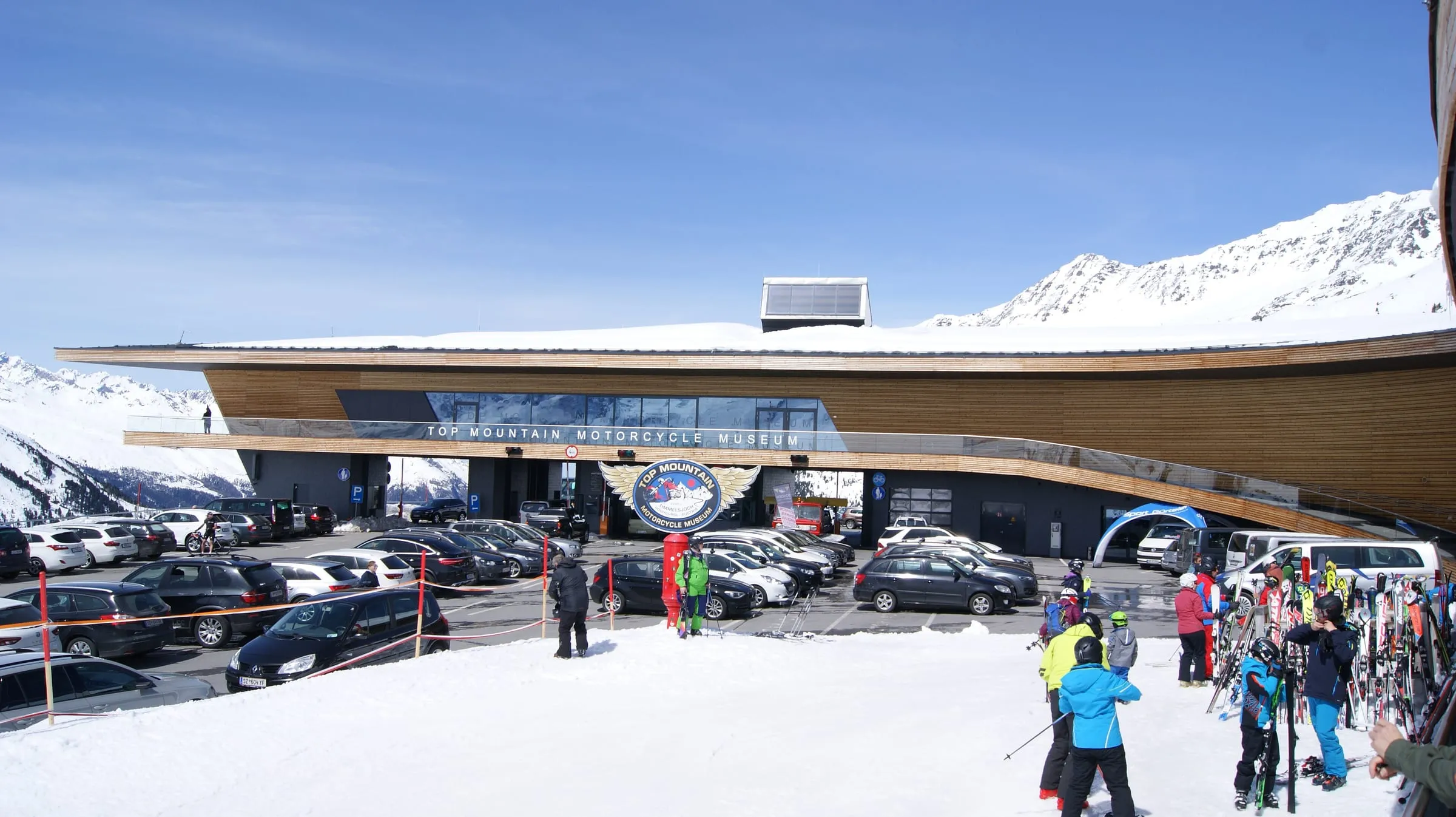 Skiers outside the Kirchenkarbahn gondola and Top Mountain Motorcycle Museum building on the Timmelsjoch road at Hochgurgl