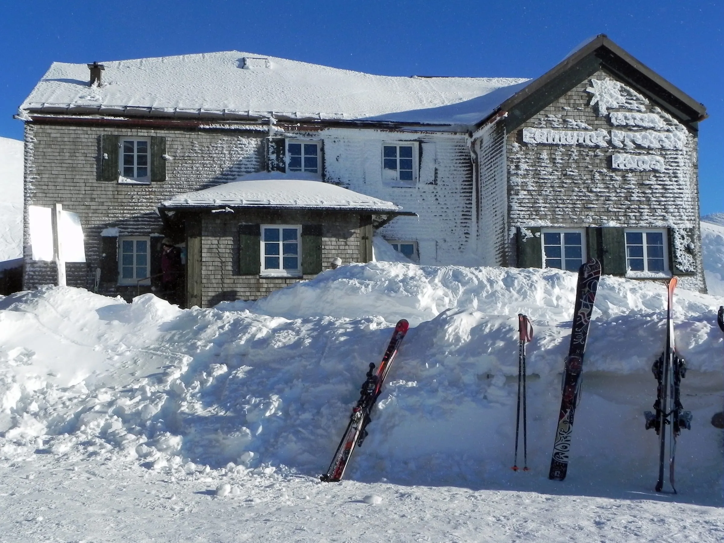 Skis outside the snow-covered Edmund-Probst-Haus near the Höfatsblick station on the Nebelhorn