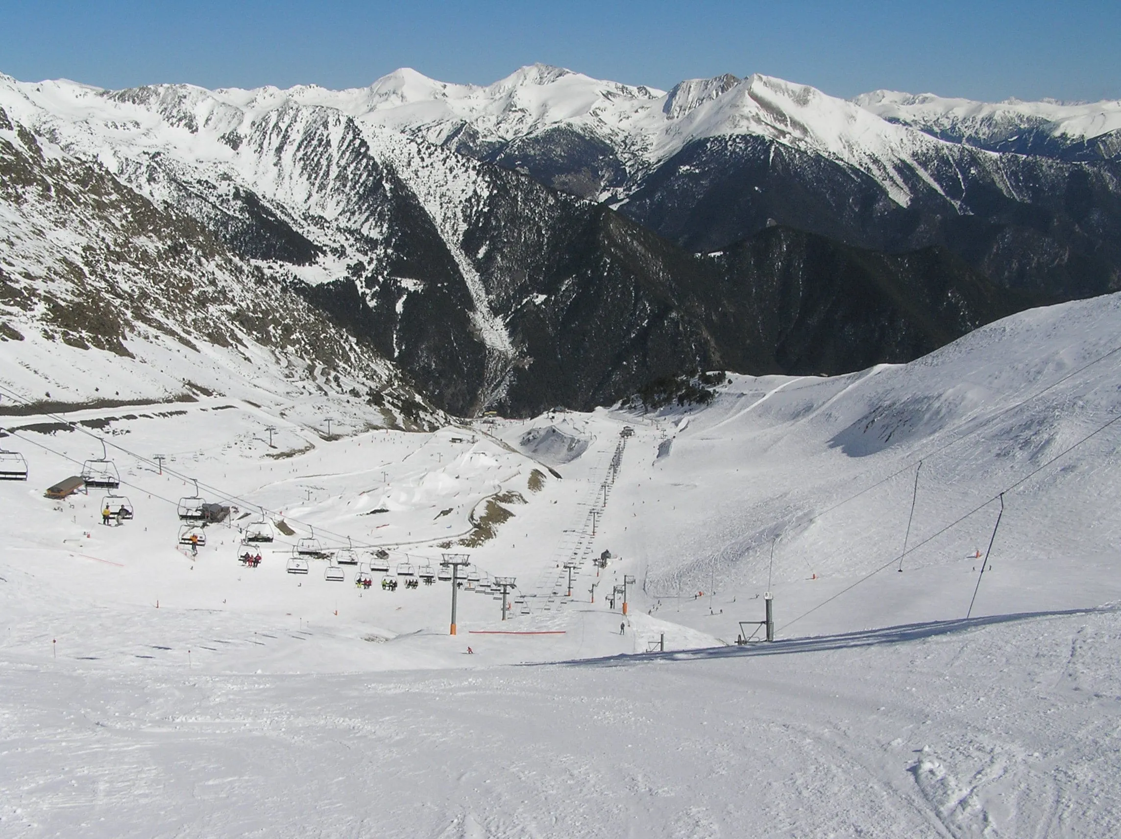 The open, treeless bowl of the Arinsal sector in winter, seen from the top, with chairlifts below