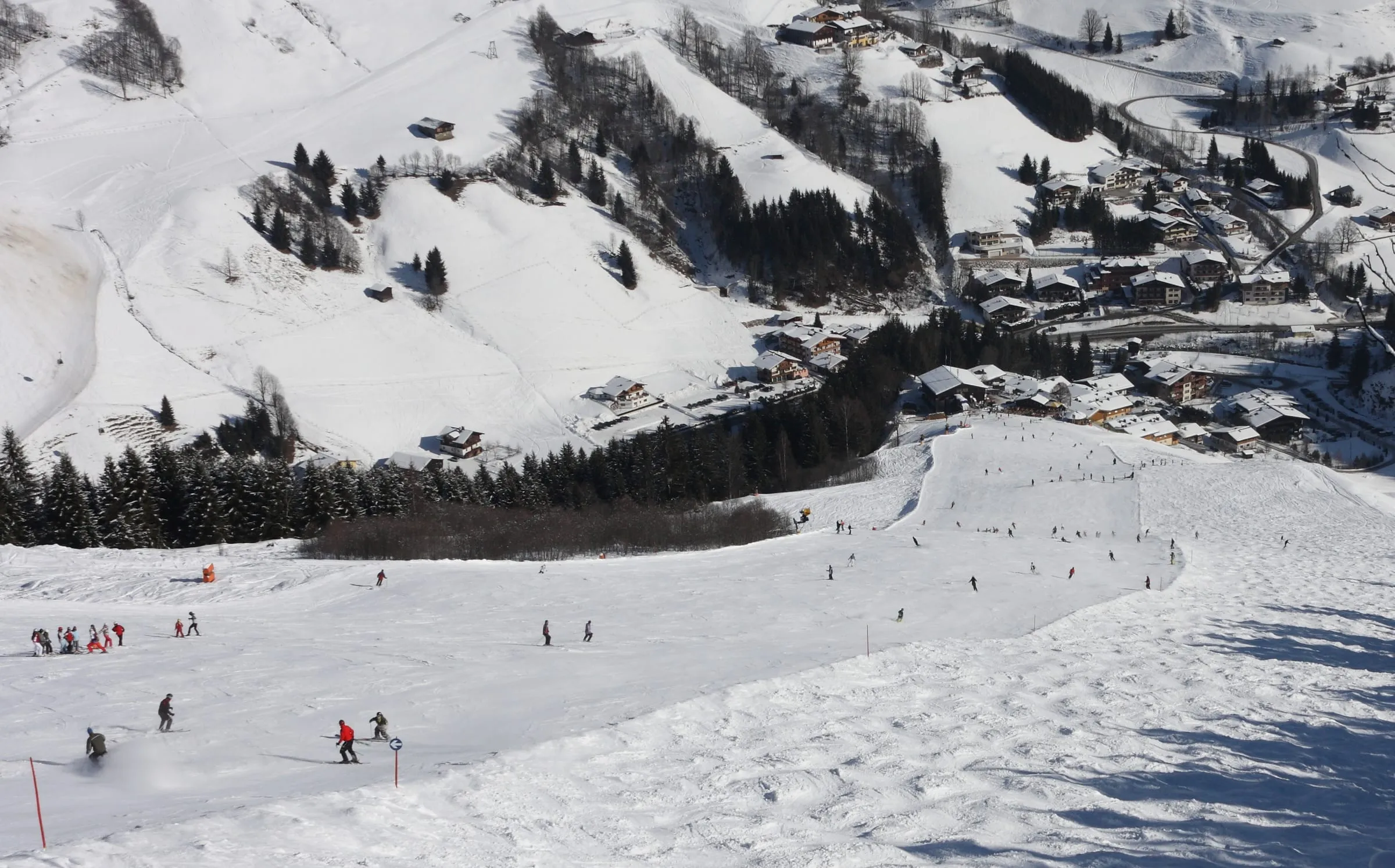 Skiers on the lower Jausern run above the village of Vorderglemm in Saalbach Hinterglemm