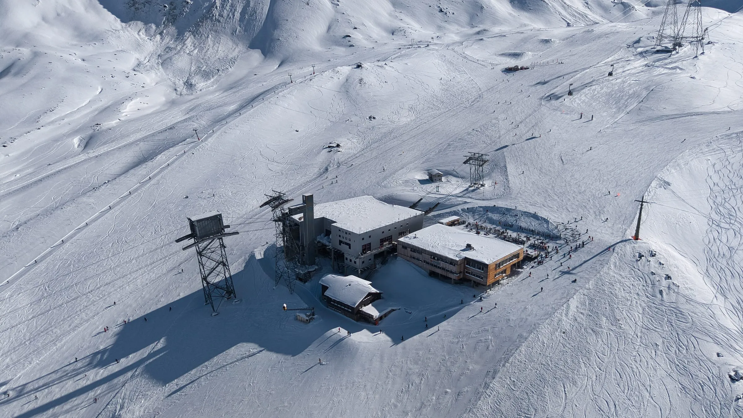 Aerial view of the Morenia lift station and pistes above Saas-Fee in winter