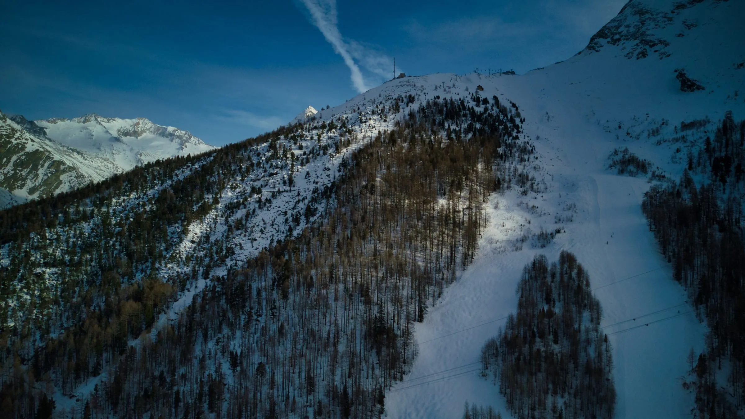 Ski run cutting through larch forest at Plattjen in the Saas valley