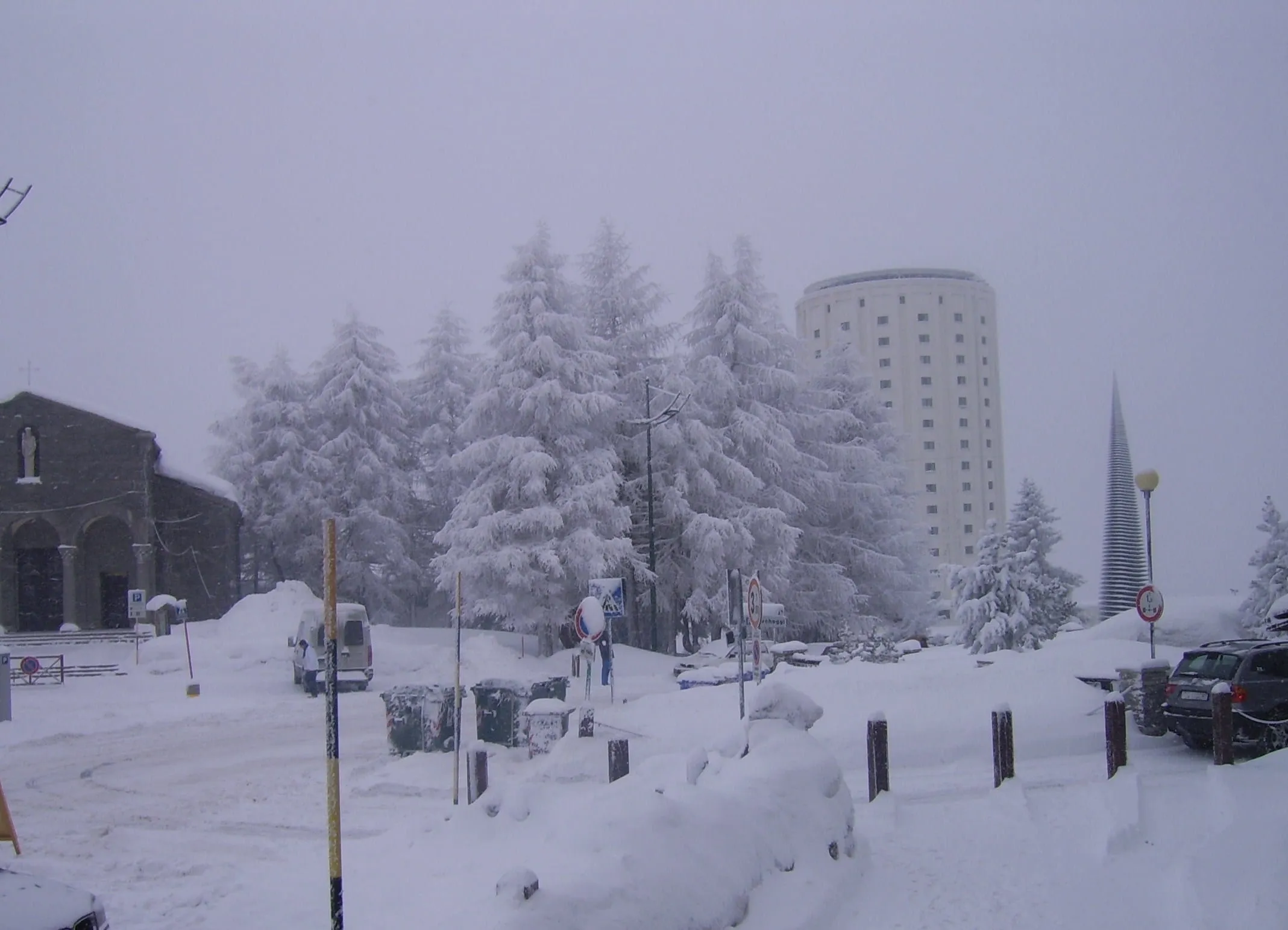 One of the Sestriere towers among snow-covered trees during a snowfall