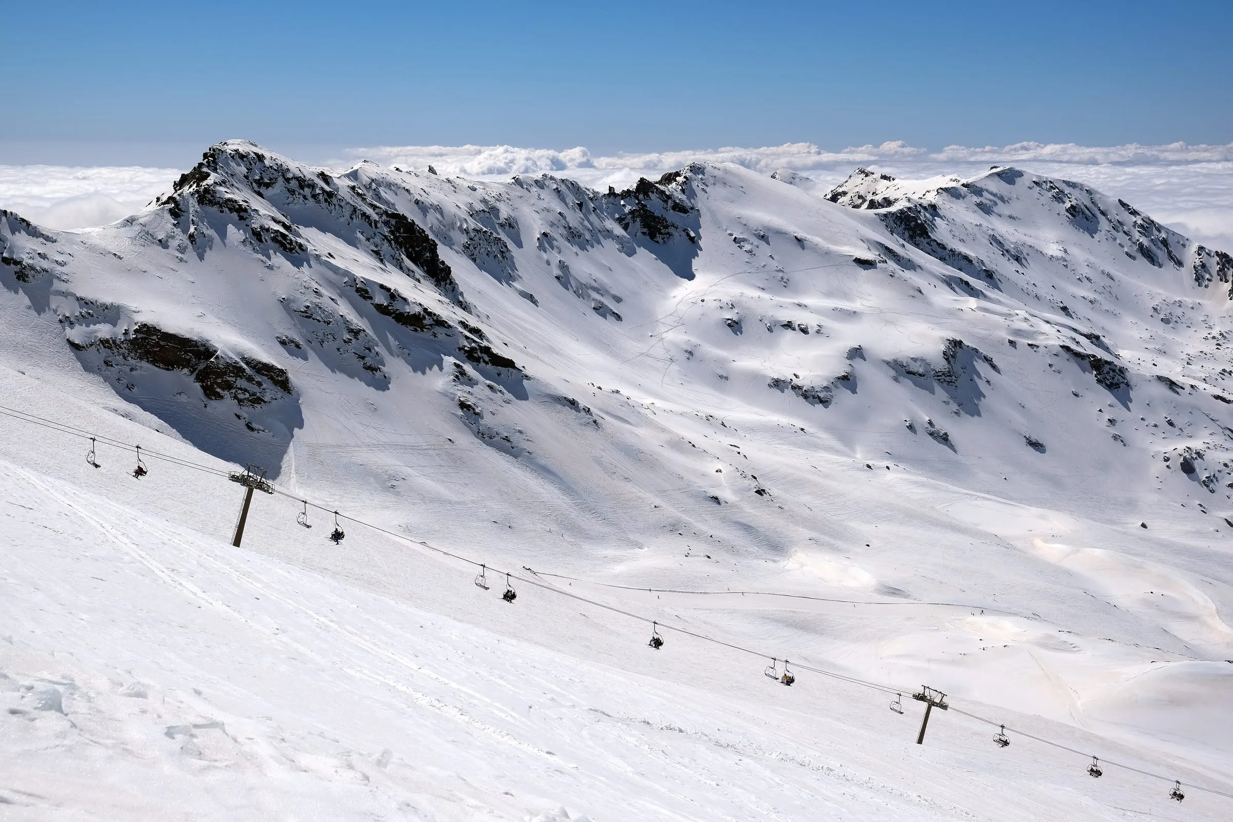 The high, snowy bowl of Laguna de las Yeguas in the Sierra Nevada ski area, with a chairlift