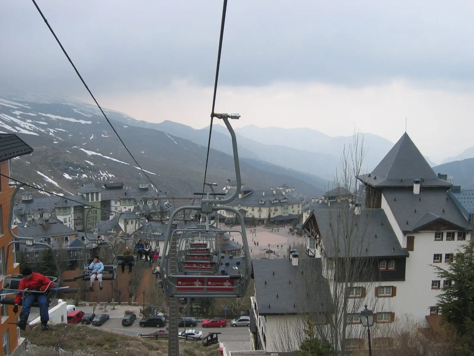 Hotels and a chairlift in Pradollano village, Sierra Nevada, with snowy slopes behind