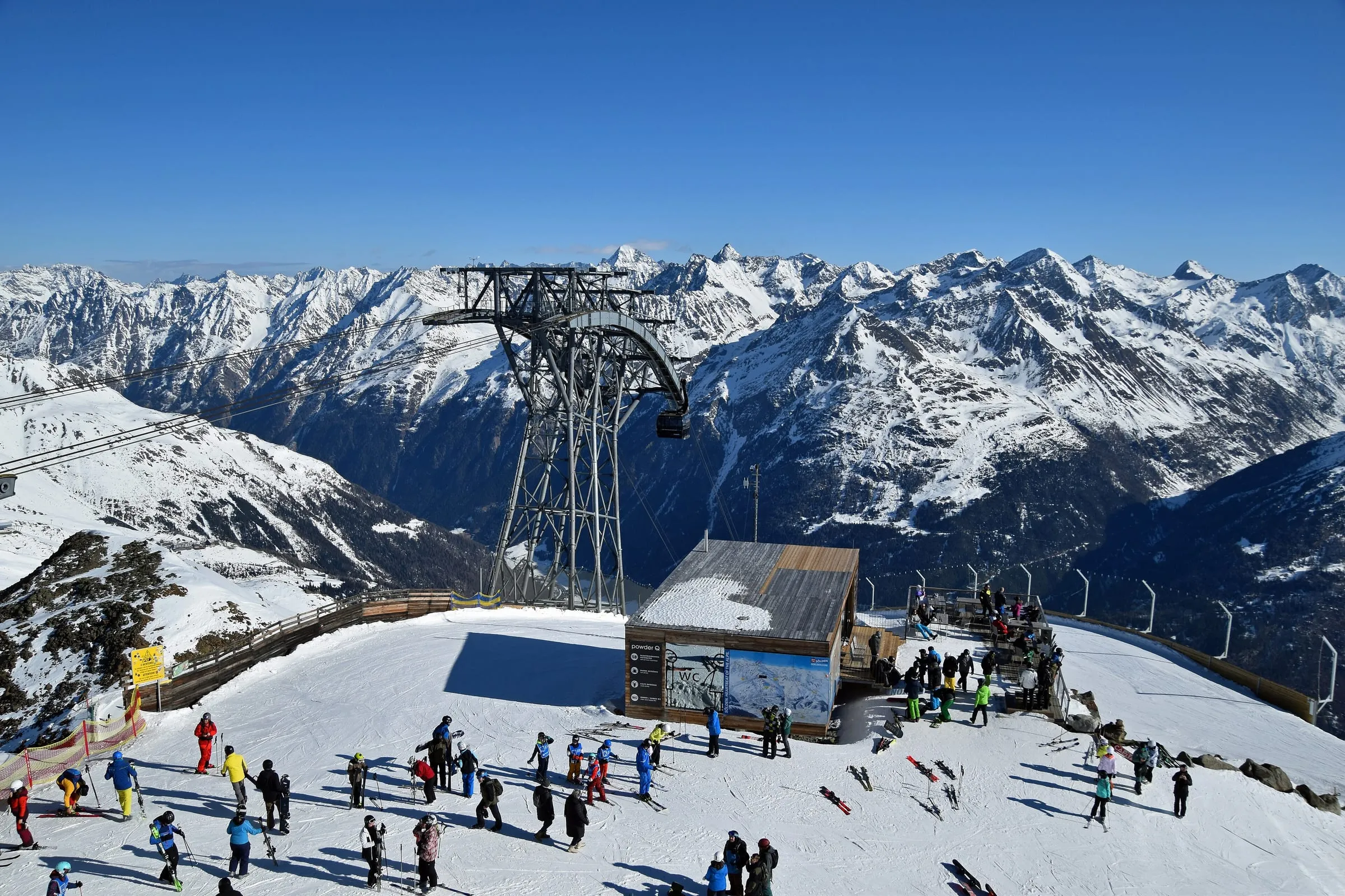 Skiers at the top station of the Gaislachkogl gondola above Sölden, with snowy Ötztal peaks