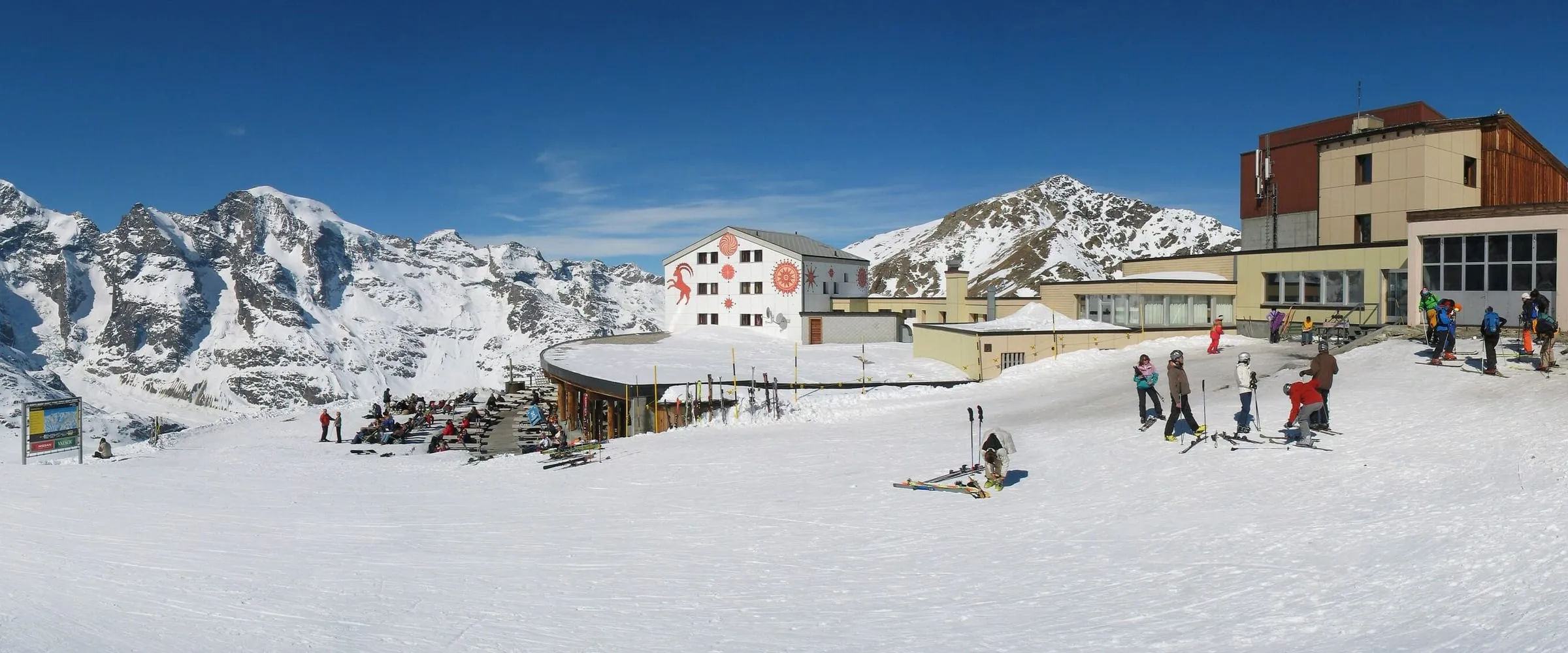 The Diavolezza mountain hut and cable-car station at the start of the Diavolezza piste, with skiers in the snow