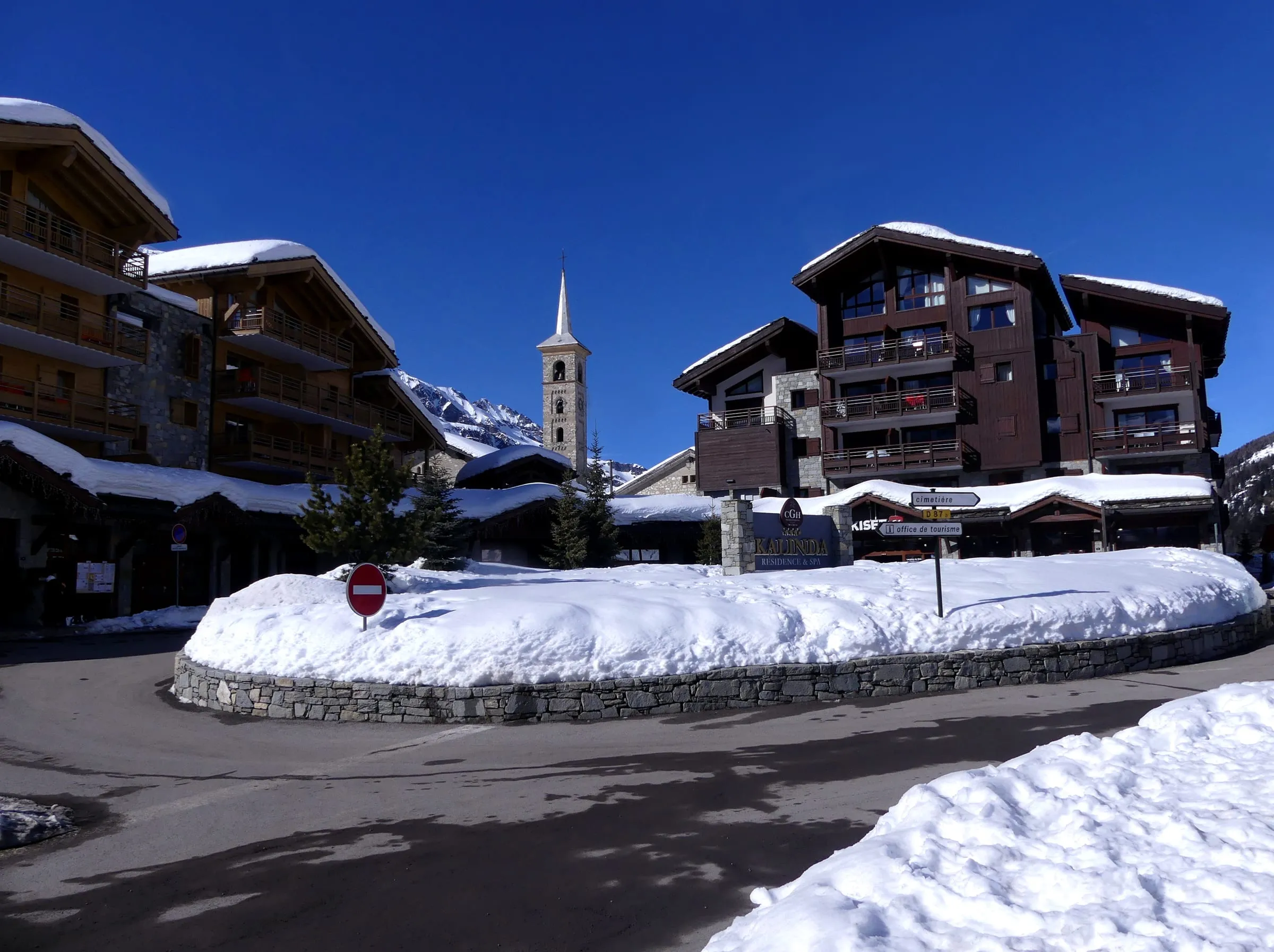 Stone and wood chalets and the church in Tignes 1800 in winter