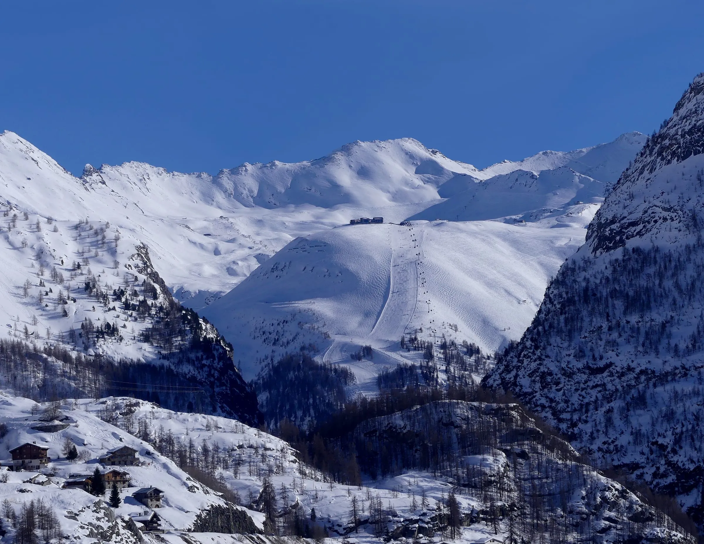 The Solaise slopes and gondola above Val d'Isère in winter, seen from the Tignes dam