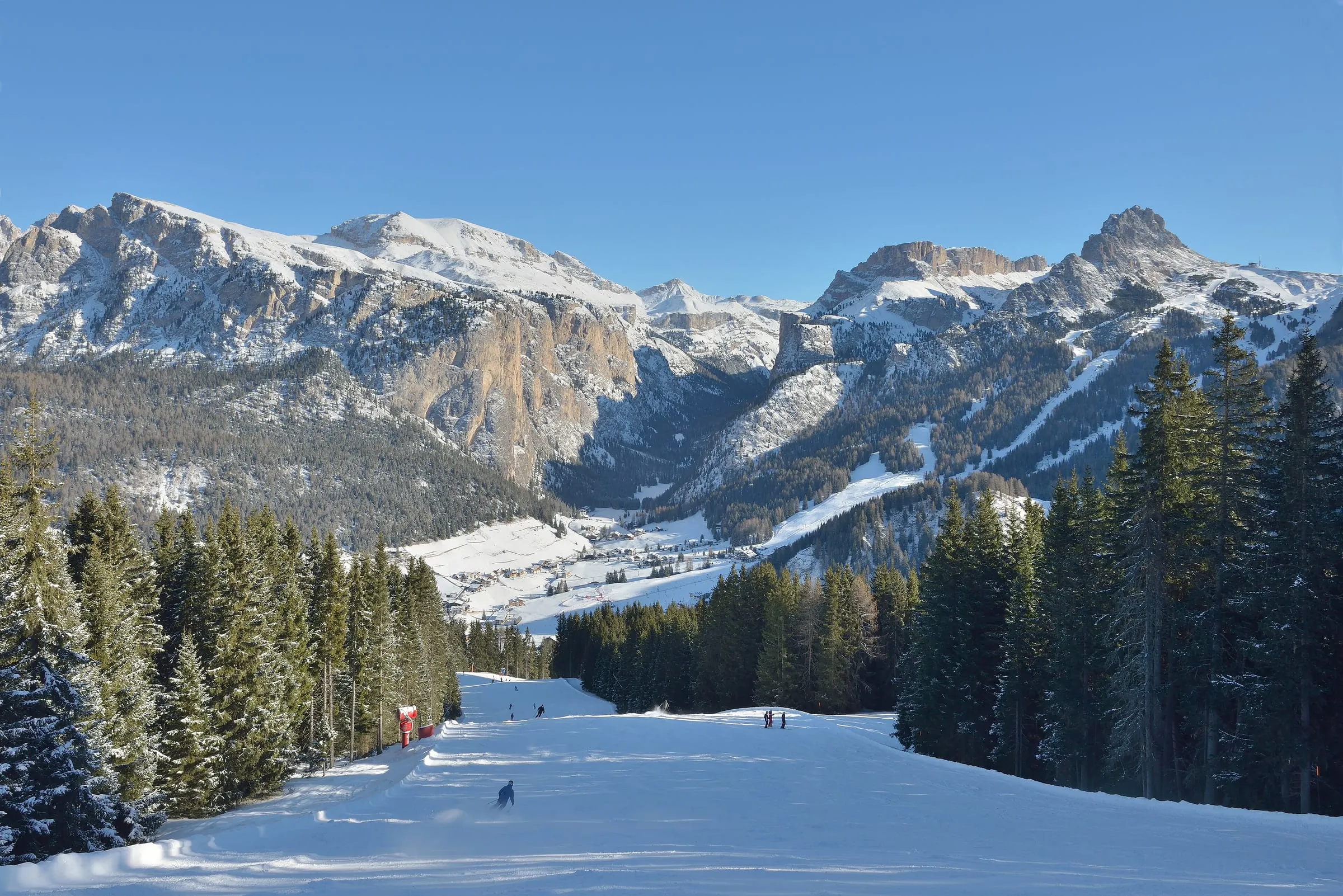 A tree-lined piste coming down from Ciampinoi towards Selva in Val Gardena