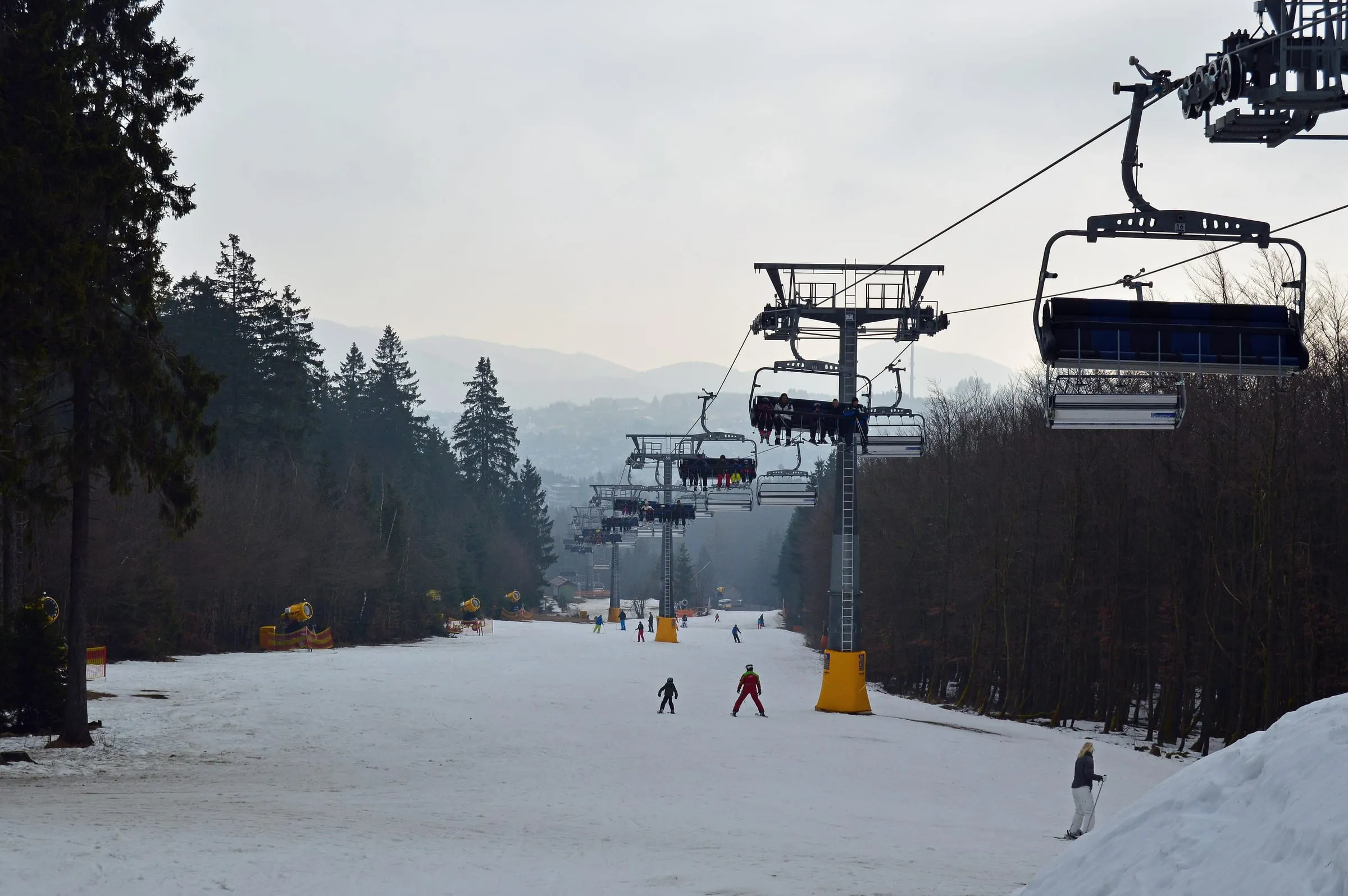 A chairlift climbing above a groomed piste in the Skiliftkarussell Winterberg