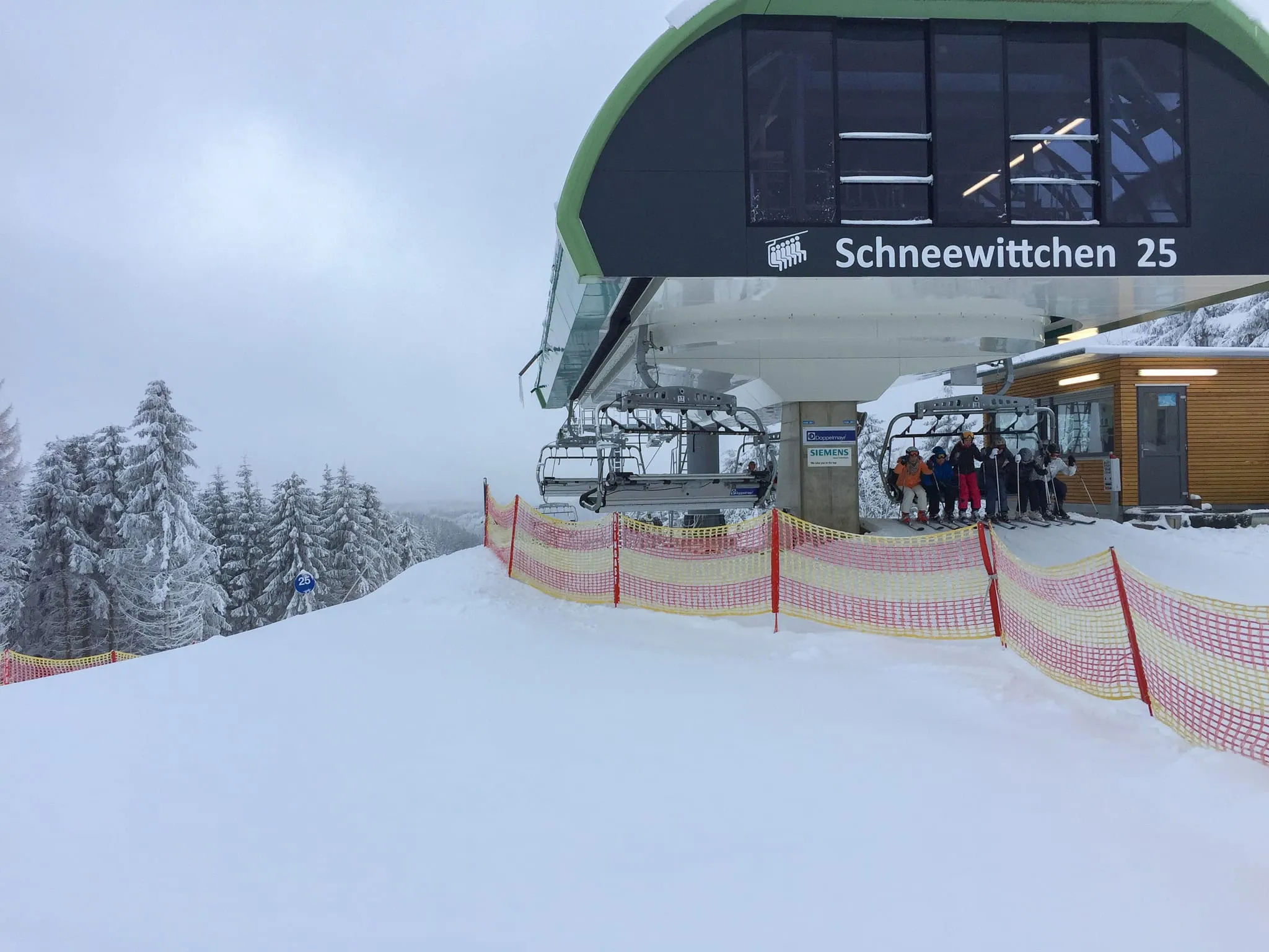Skiers at the Schneewittchen chairlift in the Winterberg ski area on a snowy day