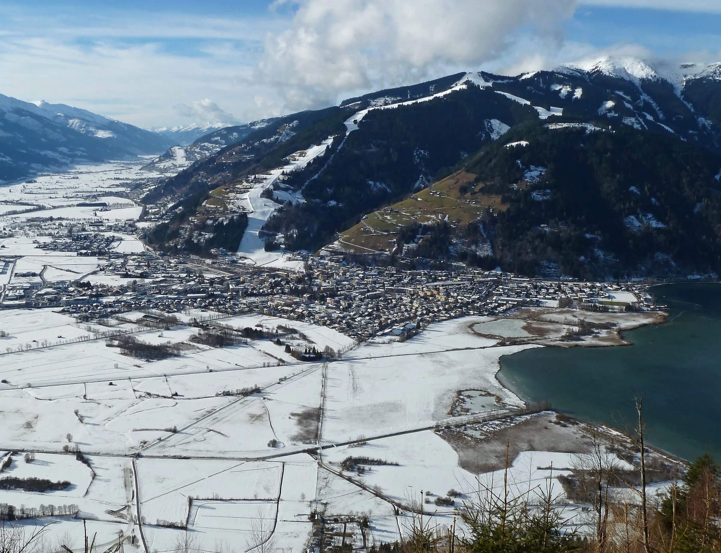 Zell am See in winter beside Lake Zell, with the snowy slopes of the Schmittenhöhe above the town